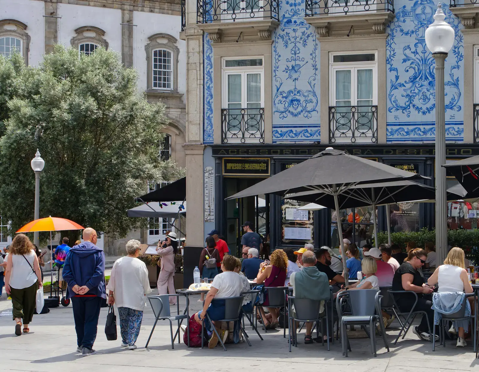 Freunde an einem Außen-Café unter gefliesten Fassaden im historischen Porto.