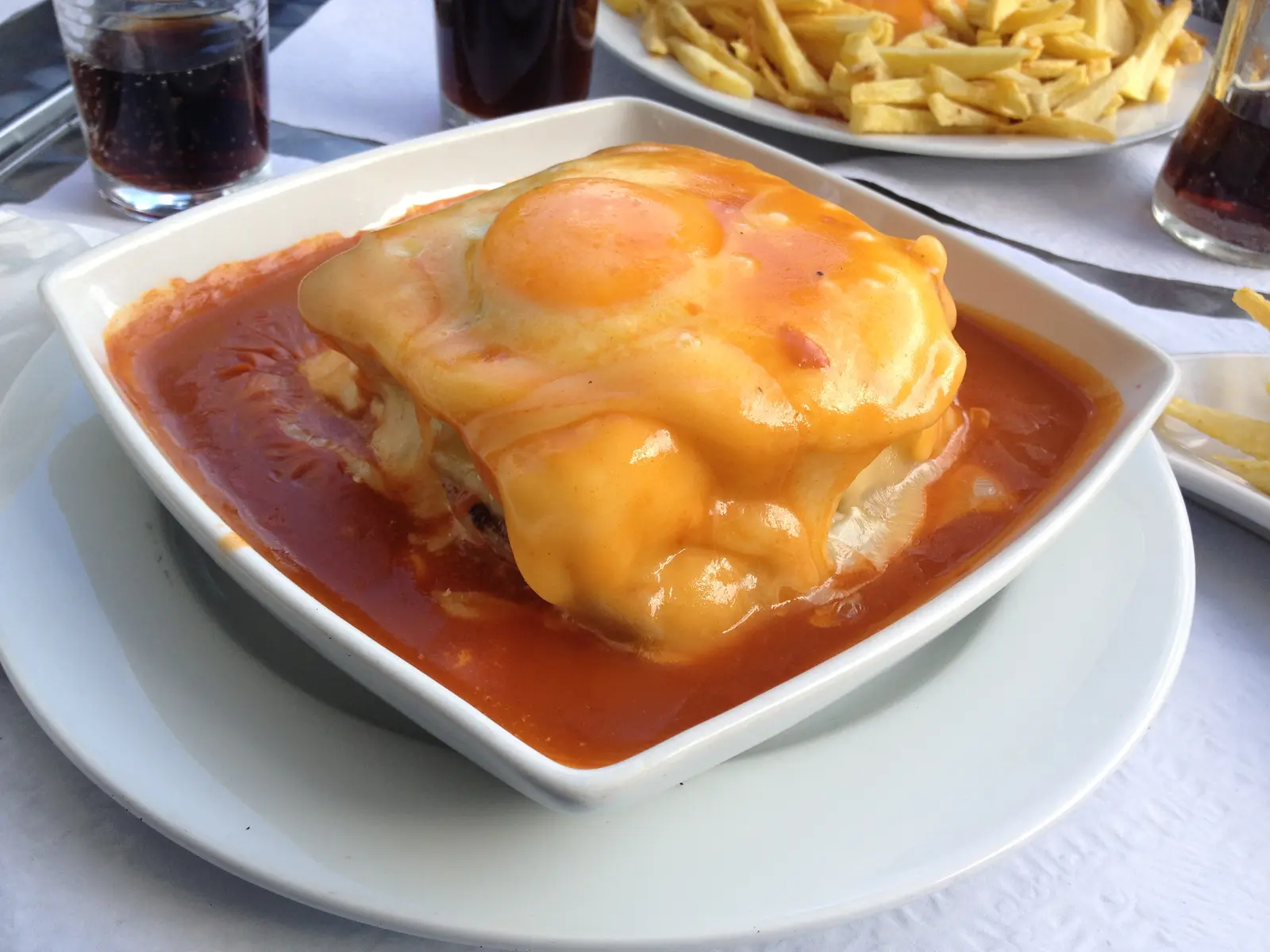 波尔图特色 francesinha,配以融化的奶酪、酱汁、煎蛋和薯条。
